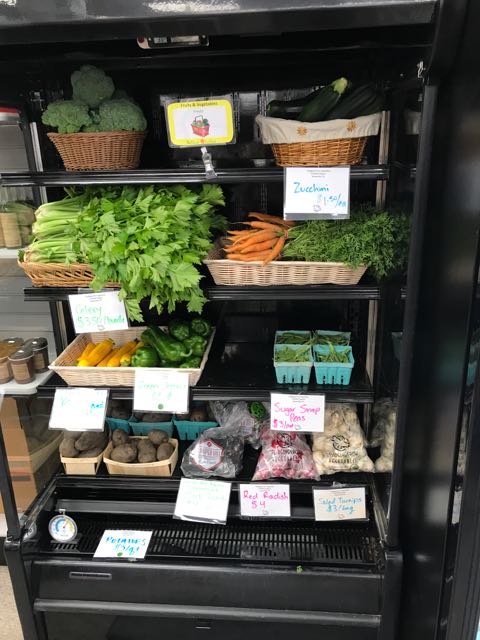 stocked grocery shelves with vegetables