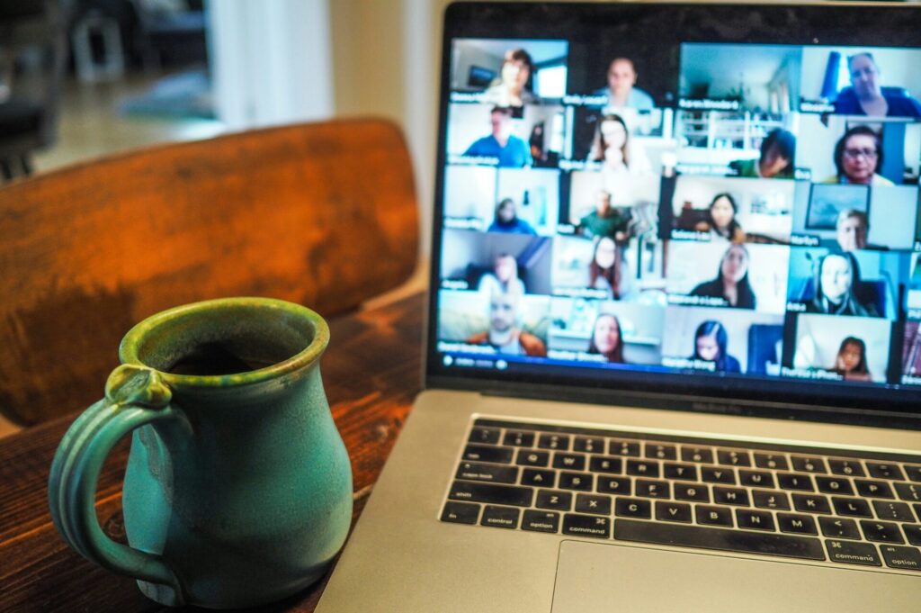zoom video conference on a laptop next to a mug